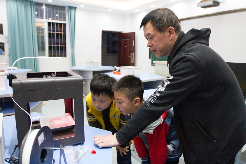 城西小学教师指导学生操作3D打印机.jpg