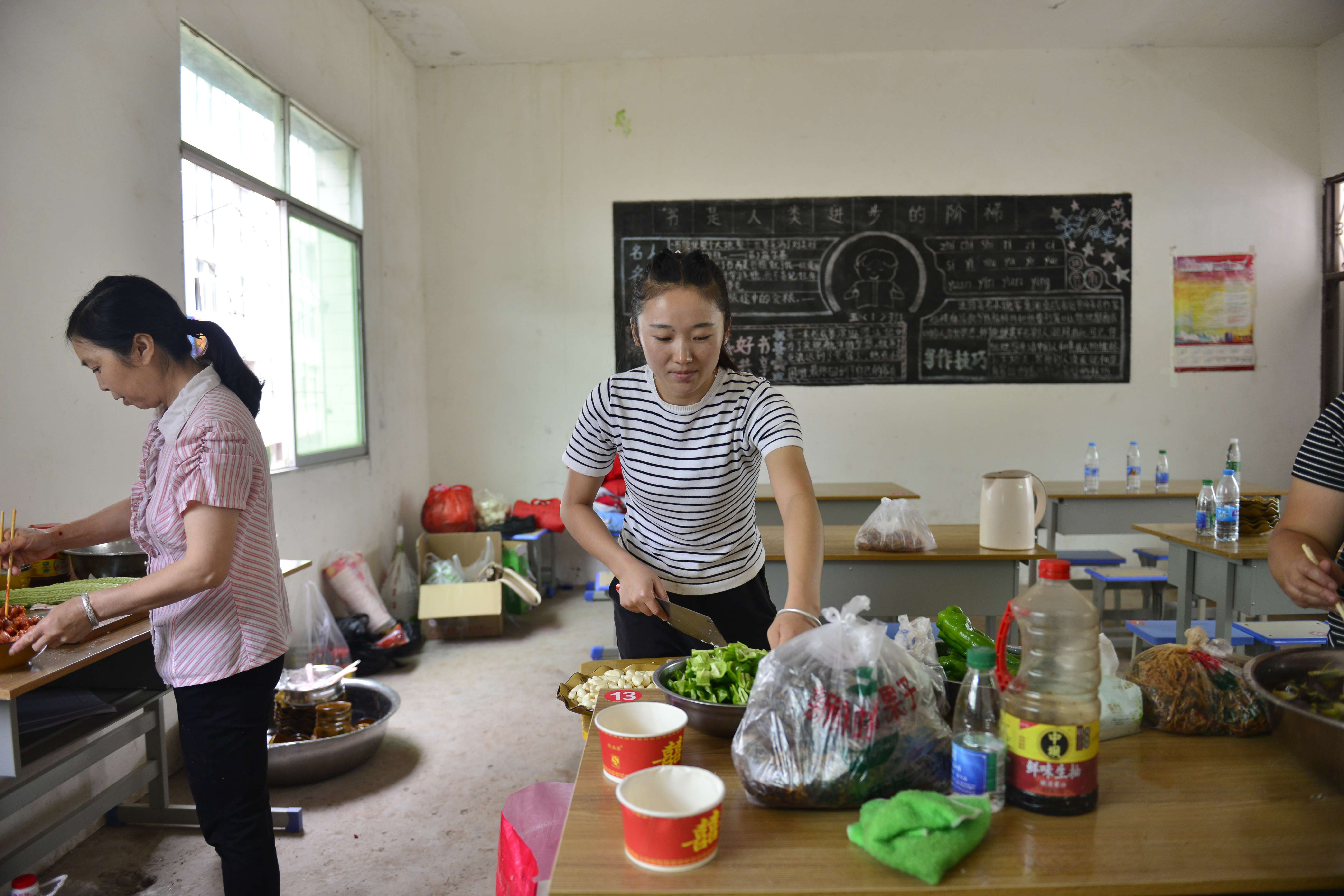 午饭时间快到了，胜利小学体育教师孙小溶主动到临时食堂帮厨.jpg