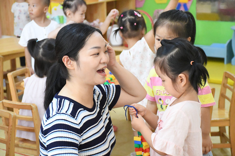 2021年9月1日，成都市新都区第一幼儿园西南石油大学分园开学第一天，小二班胡敏老师（左一）和刘新冉、涂艺欣小朋友们玩游戏。 - 复件_副本.jpg